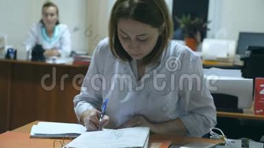年轻护士在办公室办公桌工作并书写病历.. 女医生在医院开处方